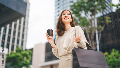 Single adult business asian woman confidence smiling holding coffee cup and shopping bag city people lifestyle