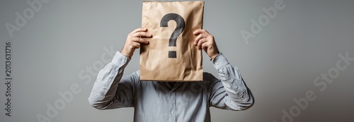 An anonymous person idea depicts a businessman in disguise with a blank, empty paper bag mask covering his face with a question mark on it.