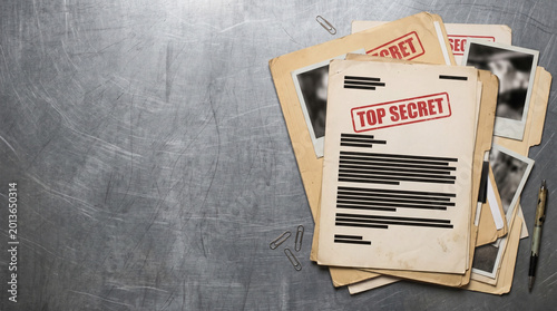 Redacted Secret Agent File Documents Resting On Metal Surface background with copy space, top view shot