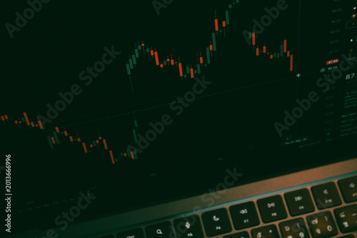 фотографія Trading Chart with Red and Green Candles on Dark Laptop Screen, Stock Market Fin