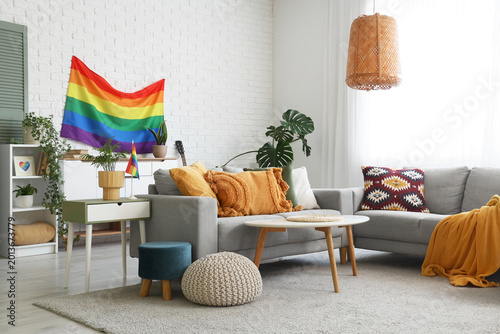 Tableau sur toile Interior of living room with LGBT flag, sofas and tables