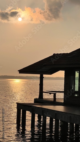 Sunset over the sea with wooden house in the foreground, Thailand