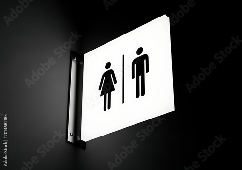 Restroom sign with male and female icons mounted on a dark wall, directional signage for public facilities and navigation