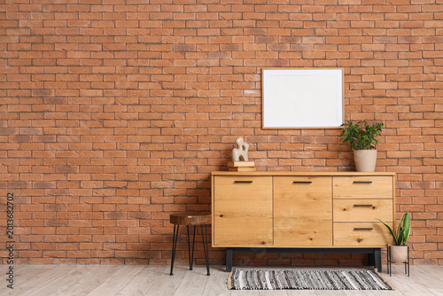 Foto Interior of room with wooden commode and blank frame
