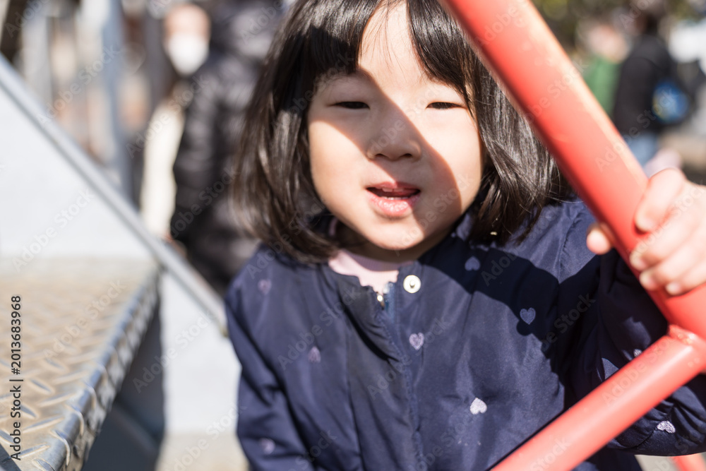 Obraz premium 公園の滑り台を滑り降りる日本人の女の子の幼児