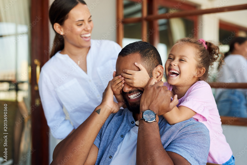 Fototapeta premium Parents, father and child with peekaboo in home, weekend bonding and laughing for happy relationship. Family, people and girl with surprise game for smile, love and playful interaction for connection