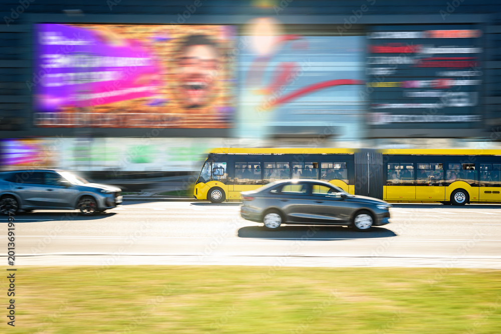 Fototapeta premium A yellow city bus driving along Minsk avenue road. Public transport in Belarus.