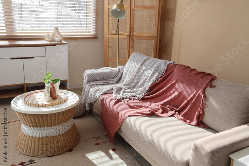 Konstfotografi Interior of living room with grey sofa, rattan table and commode