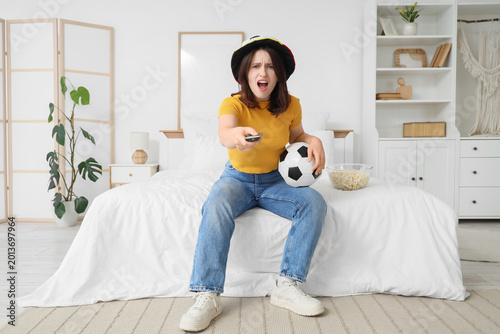 Young woman with TV remote ...