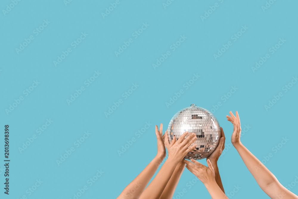 Fototapeta premium Female hands with disco ball on blue background