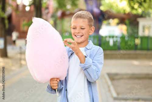 Teen boy eating cotton candy in park