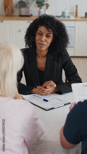 Negotiation of female insurance agent and aged married couple at home kitchen. People discussing conditions of contract of sale, rent or buy new house, property and life insurance, lawyer consultation