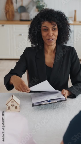 Business talks about real estate deal, aged spouses consultation with broker. Smiling african american lady discussing with clients conditions of agreements of mortgage or bank credit, shake hands