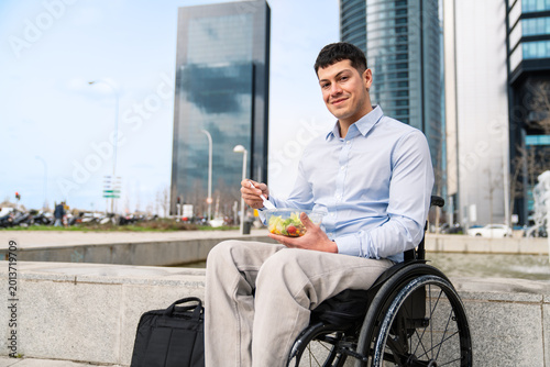 Принти на полотні Entrepreneur with disability enjoying a quick salad lunch outdoors among urban skyscrapers