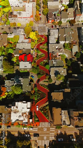 Drone shot pulling away from Lombard Street in warm San Francisco daylight