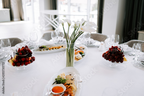 Delicious dishes and floral centerpieces at a gathering in a bright dining space