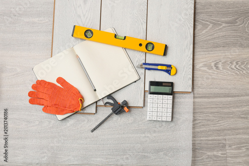 Bild auf Leinwand Tools, calculator, notebook and laminate boards on floor