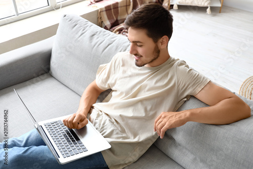 Young man using laptop on h...