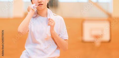 фотографія Elementary, middle, and high school girls in gym clothes wiping sweat with towels in the gymnasium