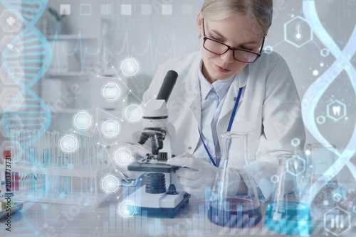 Female scientist with microscope working in laboratory. DNA research technolo...