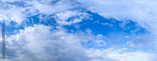 Beautiful blue sky background with cumulus clouds. Large and small vapor structures are arranged in a chain, flowing smoothly along the horizon. Wide website banner.