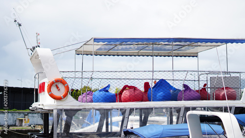 Картината върху платно The upper deck of a tour boat with colorful bean bags and a blue canopy