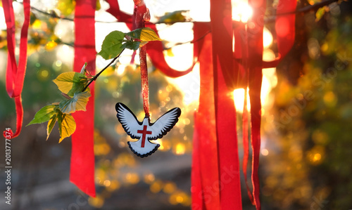 Tableau sur toile Dove pendant, red ribbons on tree branch, sunny abstract nature background