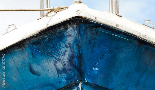 Fotografi close up of a blue painted boat hull with scratches and dents