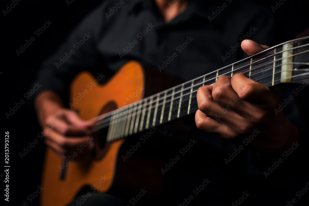 Obraz premium Close-up of an African American playing an acoustic guitar