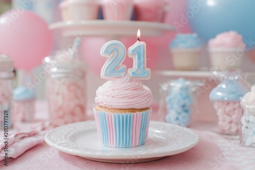 Festive pink and blue birthday cupcake with candle for twenty-one celebration