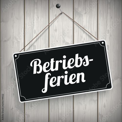 Schwarzes Schild an der Holzwand mit dem Wort Betriebsferien	