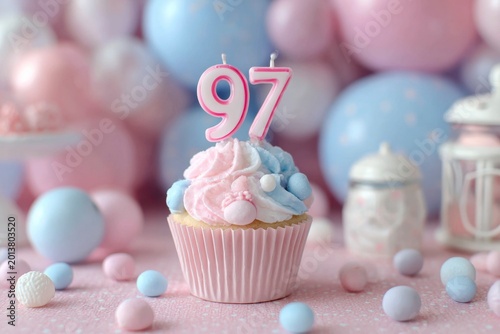 Festive cupcake with pink and blue frosting and birthday candle 