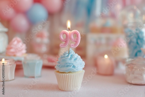 Festive birthday cupcake with pink and blue decorations and number 99 candle