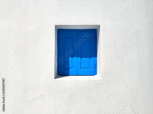 Tableau sur toile Photo of a traditional cobalt blue window on the iconic Mykonos windmills, a Cycladic architecture detail in Little Venice, Greece