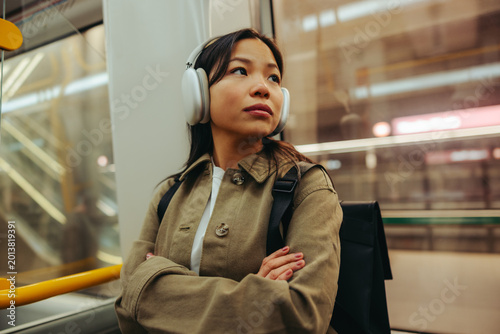 Woman with headphones commuting on a city metro