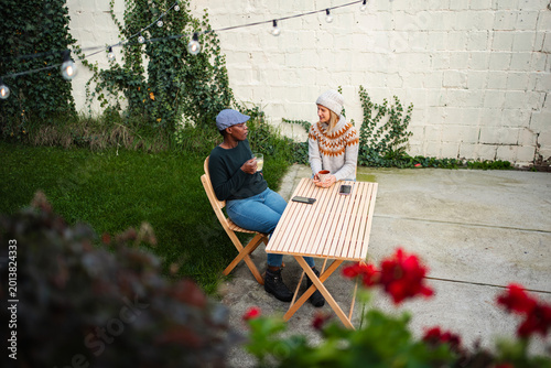 Quadro su tela Diverse friends enjoying coffee conversation in backyard garden