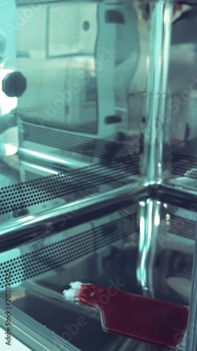 In a sterile cleanroom, a technician in a medical laboratory meticulously handles a sample, emphasizing precision in the pharmaceutical industry.