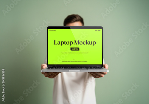 A man holding a laptop in front of him for a mockup
