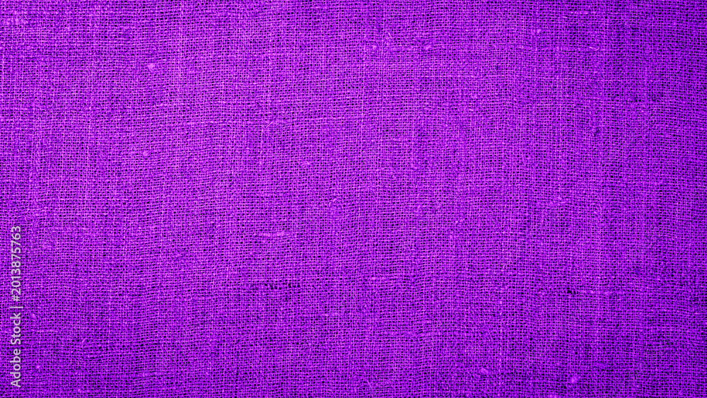 Fototapeta premium Bright purple fabric draped on a surface during a crafting session in a sunny workspace