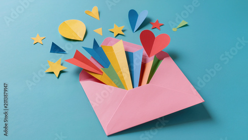 Colorful Paper Shapes Exploding from Pink Envelope on Blue Background