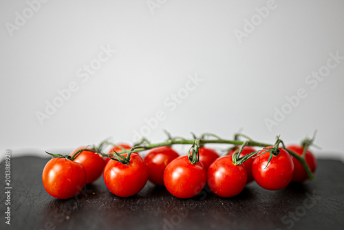 Tableau sur toile Small organic cherry vine tomatoes placed on a grey slate or stone kitchen surface