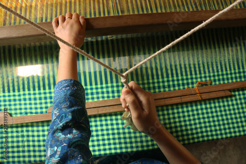 Handloom weaver in India working in loom.