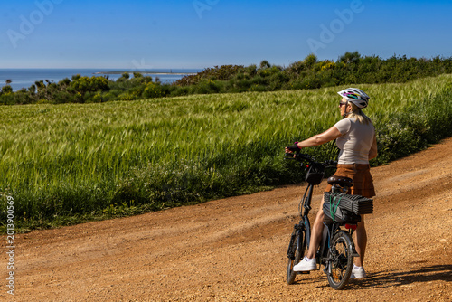 Woman Riding Electric Bicycle on Gravel Road Near Medulin, Croatia
