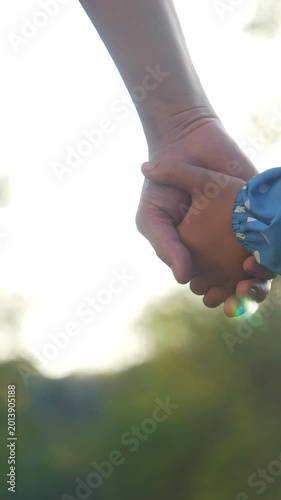 A woman's hand is extended toward the camera, capturing the details of her gesture. The background features a scenic environment with soft lighting and greenery.