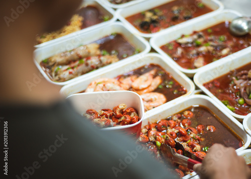 Quadro su tela Crustacean scoop moment captures tongs selecting chilicoated crustaceans from a