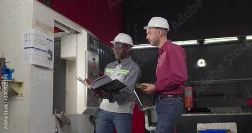 Sales engineer meets a client in an industrial workshop, reviewing quotation details, discussing costs and capabilities, and negotiating terms for a custom production project.
