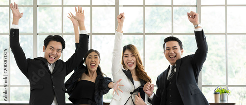 Cheerful of Asian business people or Asian colleagues team raise your hand together, complated of cooperate for work or investment strategy