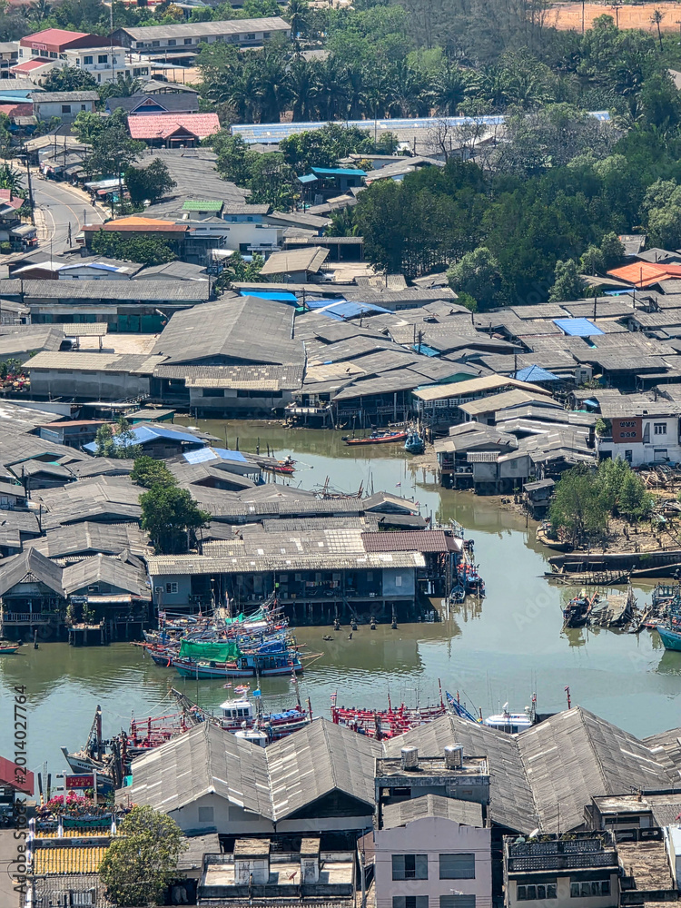 Fototapeta premium Aerial view captures tranquil rustic fishing village community featuring wooden house structure on stilt over water reflecting resilient lifestyle of traditional waterfront settlement