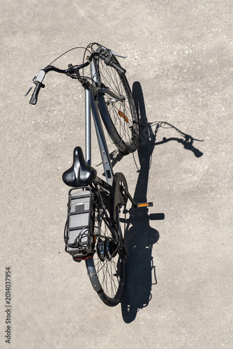 Top view of a classic bicycle on pavement, aerial view of a parked bike, summer leisure concept