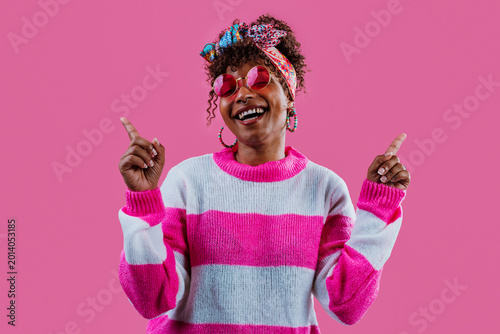 Obraz na plátně Influencer showing and pointing with excitement on pink background